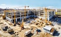 Top view on big construction site with cranes and industrial machines at bright sunny day.