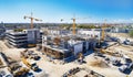 Top view on big construction site with cranes and industrial machines at bright sunny day.