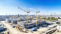 Top view on big construction site with cranes and industrial machines at bright sunny day.