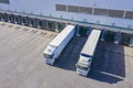 Top view at a Big distribution warehouse with gates for loads and trucks. Aerial View