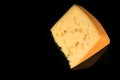 top view of big piece of hard porous yellow cheese with holes