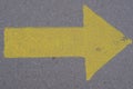 Top view of a big yellow traffic arrow right sign painted on a concrete ground outdoors