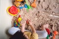 Top view of toddler boy playing with sand alone at home, Fine motor skills development, Montessori education, Creative play for