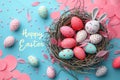 Top view of bird nest with colorful easter eggs inside on blue background Royalty Free Stock Photo