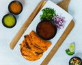 Top view of birria tacos plate on a wooden board with cilantro, onions, salsa, and lime Royalty Free Stock Photo