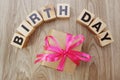 Birthday alphabet wooden cube with gift box present on wooden background Royalty Free Stock Photo