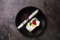 top view biscuit roll with berries on a stylish black plate