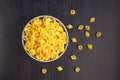 Top view of black background with italian raw conchiglie paste shells in bowl with copy space