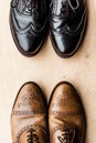 Black and brown pairs of leather shoes on wooden floor Royalty Free Stock Photo