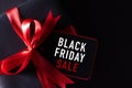 Top view of black christmas boxes with red paper tag on black background with copy space for text. black Friday composition Royalty Free Stock Photo