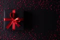 Top view of black christmas boxes with red ribbon on black background with copy space for text. black Friday composition Royalty Free Stock Photo