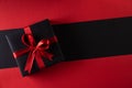 Top view of black christmas boxes with red ribbon on black background with copy space for text. black Friday and Boxing Day Royalty Free Stock Photo