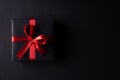 Top view of black christmas boxes with red ribbon on black background with copy space for text. black Friday composition Royalty Free Stock Photo