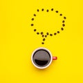 Top view black coffee or Americano in red cup and coffee beans on yellow Royalty Free Stock Photo