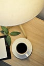 Top view of Black Coffee on Wooden Table with Lighting from Table Lamp