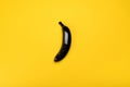 Top view of black colored banana isolated on yellow