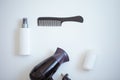 Top view of a black comb, white neutral hair spray bottle, black and purple hair dryer and a white neutral hair conditioner bottle Royalty Free Stock Photo