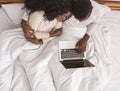 Top view of black couple using laptop in bed Royalty Free Stock Photo