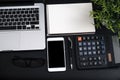 Top view, black desk with computer graph, magnifier and calculator