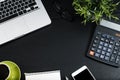 Top view, black desk with computer graph, magnifier and calculator