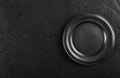 Top view of black empty plate on black stone background