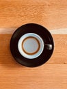 Top view of a black espresso machiatto cup on a wooden table