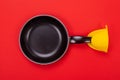 Frying pan with oven MITT isolated on red background