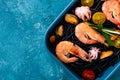 Top view black pasta with seafood-shrimp, mussels, octopus, cherry tomatoes in blue plate on gray background, Mediterranean Royalty Free Stock Photo