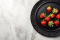 Top View of Black Plate on White Marble Background with Three Strawberries AI Generated Royalty Free Stock Photo