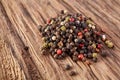 Top view on black, red and white peppercorns on wooden background, shallow depth of field.