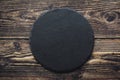 Top view of black slate round stone on wooden background Royalty Free Stock Photo