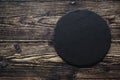 Top view of black slate round stone on wooden background with copy space Royalty Free Stock Photo