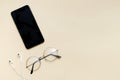 Top view of black smartphone with blank screen and wire headphones, glasses goggles for reading, mobile phone as music gadgets on Royalty Free Stock Photo