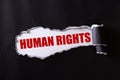 Top view of Black torn paper and the red text HUMAN RIGHTS on a white background. Human rights concept