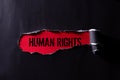 Top view of Black torn paper and the text HUMAN RIGHTS on a red background. Human rights concept Royalty Free Stock Photo