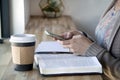 Top view of Black woman studies her bible and uses phone