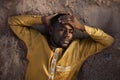 African American Man Lying in Sand and Looking Away Pensively Royalty Free Stock Photo