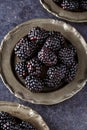 Top view on blackberries in plate on dark table background Royalty Free Stock Photo