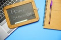 top view of blackboard with homeschooling message next to notebook computer and pen.covid 19 home school concept. flat lay Royalty Free Stock Photo
