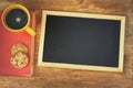 Top view of blank blackboard next to coffee cup over wooden table Royalty Free Stock Photo