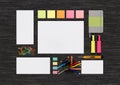 Top view of blank colorful stationery mock up on black office de