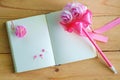 Blank diary notebook and pink flower on wooden table Royalty Free Stock Photo