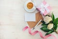 Top view of blank note, kraft envelope, coffee cup and peony flowers over white wood rustic background.Copy space. Royalty Free Stock Photo