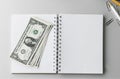 Top view of blank notebook with money dollar bills on desk