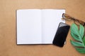 Top view with blank notebook,smartphone,glasses,green leave on brown wood table background Royalty Free Stock Photo