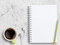 Top view blank notebook,white earphone,pencil,cup of coffee on white marble Royalty Free Stock Photo