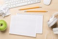 Top view of blank notepad, keyboard, headphones, apple and crumpled papers Royalty Free Stock Photo