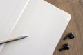 Top view of blank open notebook page, pencil and wireless headphones on wood table Royalty Free Stock Photo