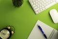 Top view of blank paper page on green background office desk and different objects. Minimal flat lay style Royalty Free Stock Photo