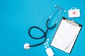 Top view of blank paper for writing doctor prescription with stethoscope. Pills on blue background. Health care concept. Top view Royalty Free Stock Photo